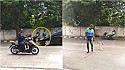 Motoqueiro estaciona moto para ajudar cachorro de rua a atravessar via movimentada.