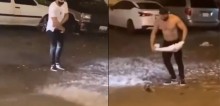 Em meio a chuva forte, rapaz tira a própria camisa para resgatar gambá