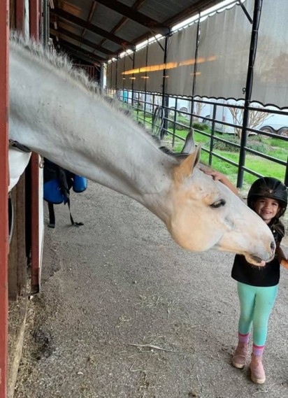 Menina de 5 anos é tão encantada por cavalos que leva um escondido