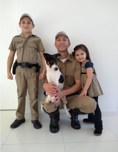 Foto: Polícia Militar Rodoviária/Divulgação Cabo Maurício, da Polícia Militar Rodoviária de Santa Catarina, posa com os filhos ao lado do cãozinho recém-adotado.