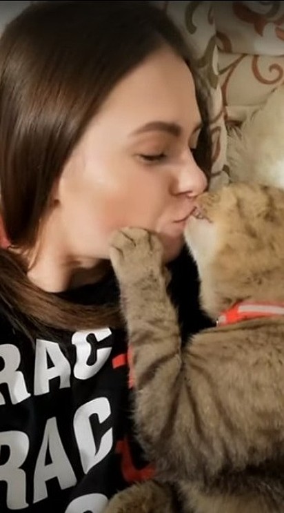 Dona e gatinha estão se beijando