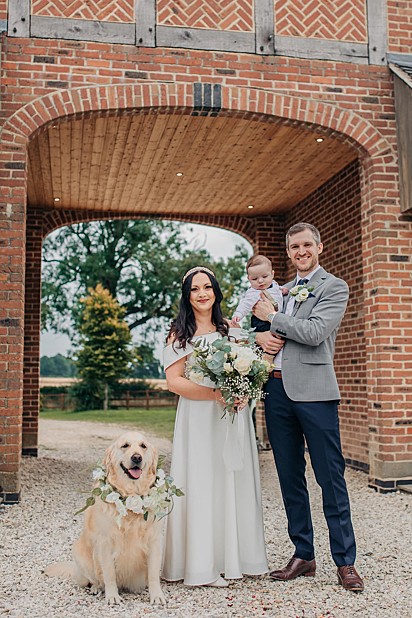 Marido, mulher, filho e cachorra possam para foto