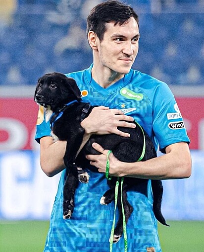 Jogador do Zenit está segurando um cãozinho preto