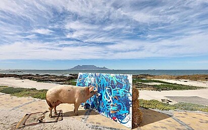 A artista está com sua obra de arte Wild and Free em uma praia.