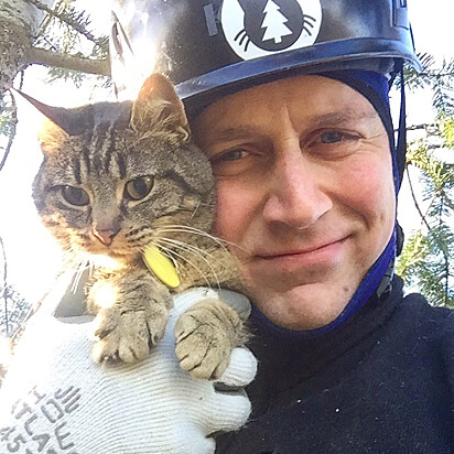 Voluntário de rosto colado com um gatinho salvo.