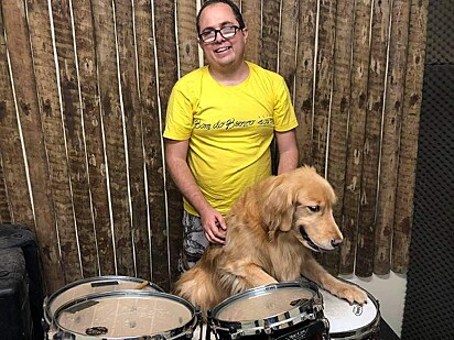 A cachorra está tocando bateria na companhia de Thiago.
