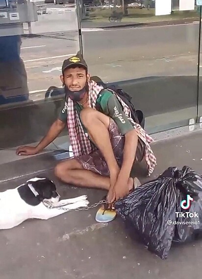 O morador de rua está cuidando de sua cadela Amora.