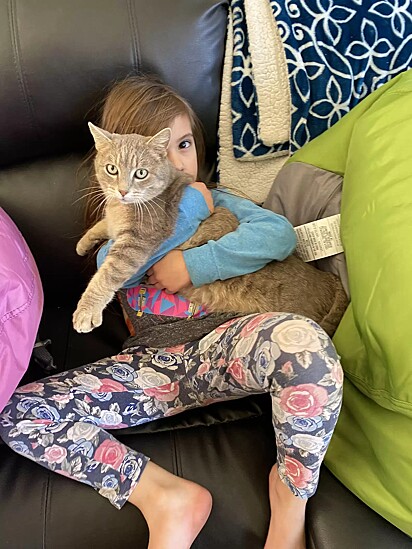 A gatinha no colo da filha da tutora.