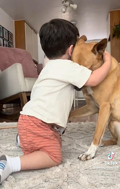Bebê abraçando a cachorrinha.