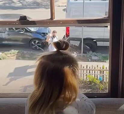 Lillian olhando o cão pela janela.