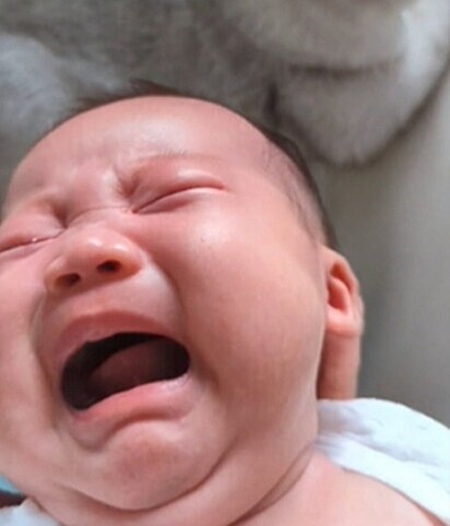 O bebê chorando.