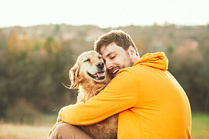 Imagem ilustrativa. Rapaz abraçando cãozinho.