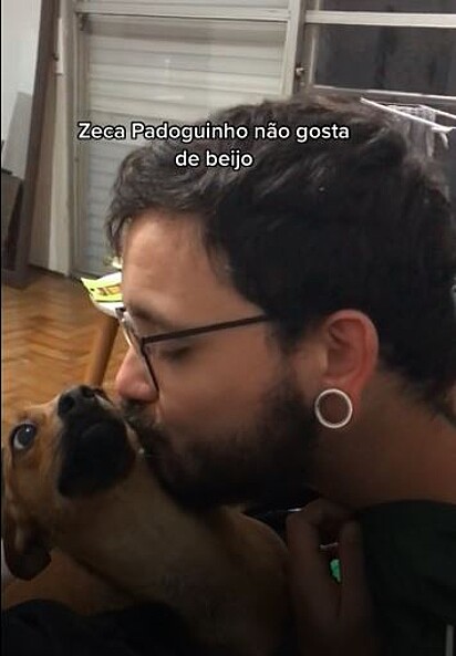 Por um momento o tutor consegue dar um beijo em um Zeca Padoguinho nada confortável com a situação