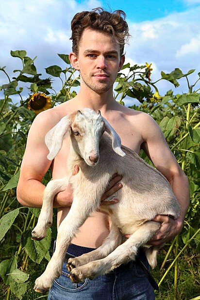 Fazendeiro segurando uma cabra no colo.