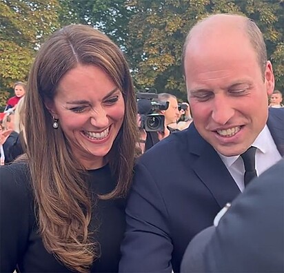 O casal sorri após o comentário do príncipe.
