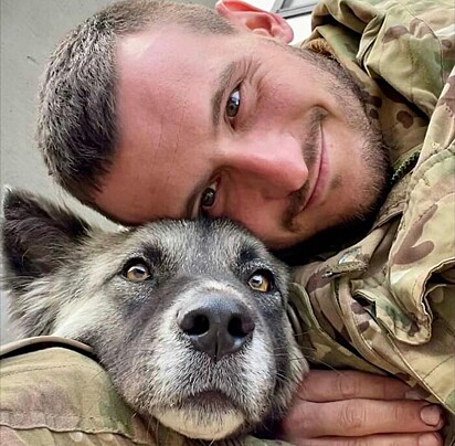 O soldado está abraçando um cão
