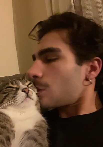 O rapaz beijando a gatinha.