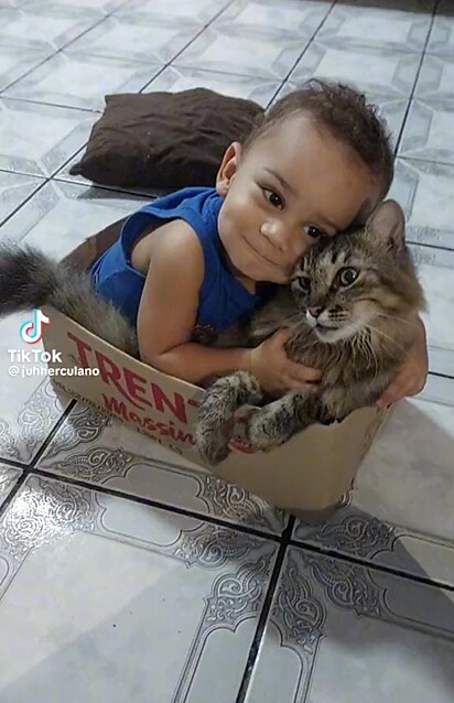 Theodoro e o bebê dividindo a caixa de papelão.