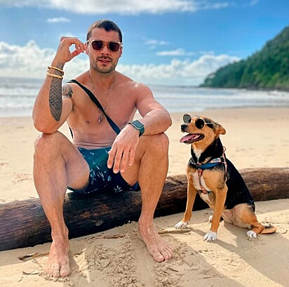 Tutor e cachorrinha na praia.