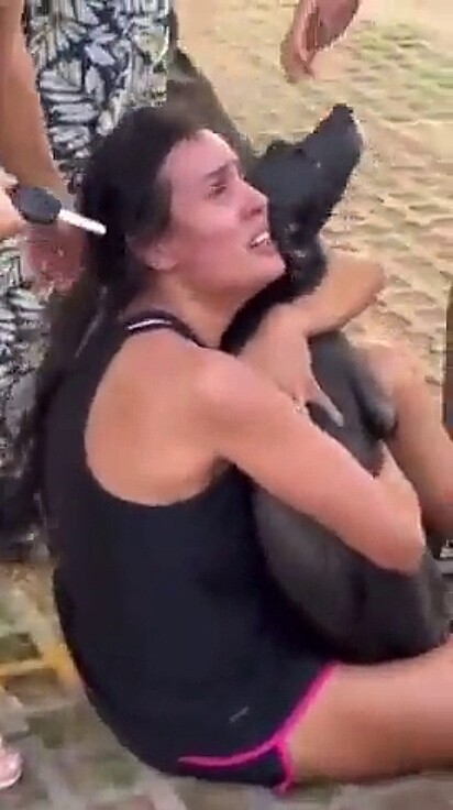 Ana abraça aliviada sua cachorrinha, que foi salva pelos bombeiros.