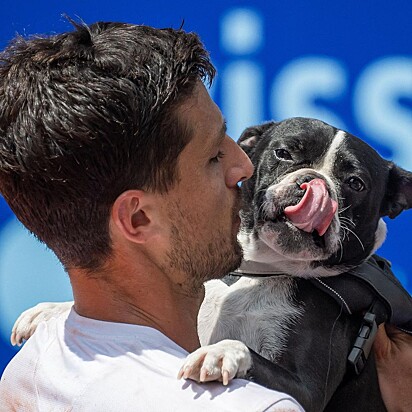 O tenista segurando no colo Tango, seu cão da raça buldogue francês.