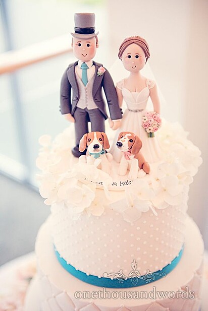 Bolo de casamento com decoração de cachorros junto com os noivos.