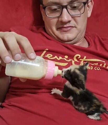 Renato dando a mamadeira para a gatinha.