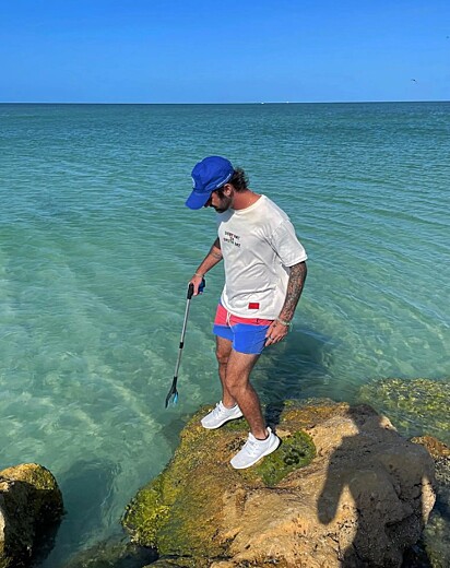 O ecoativista e influenciador Caulin recolhe lixos em praias na Flórida.