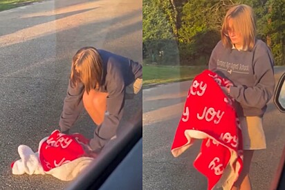 Com muito cuidado, a jovem recolheu o gambá e colocou no carro. 