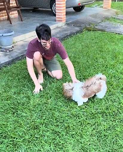 Ele brincando com o cachorro que não queria.