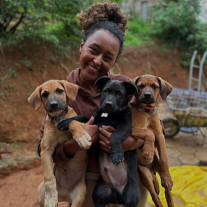 Malaika segurando no colo os seus cães.