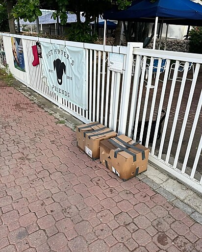 As caixas foram deixadas em frente ao abrigo. 