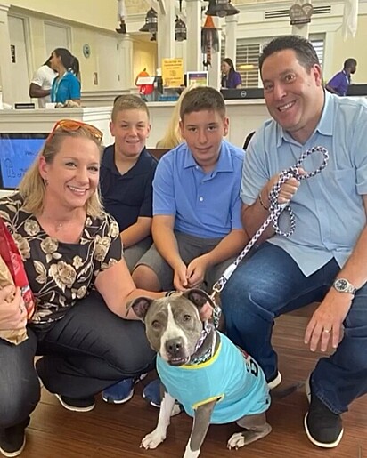 Sade sorrindo para a foto com sua nova família.