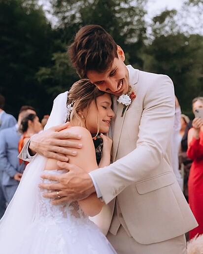 A noiva emocionada ao ganhar um filhote de cachorro no dia do seu casamento.