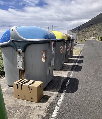 Ao lado das lixeiras, havia uma caixa de papelão lacrada com fita adesiva.