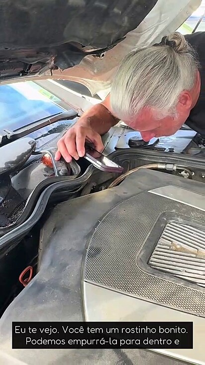 O mecânico verificando o motor.