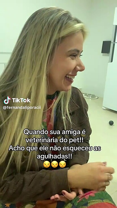 A veterinária parecia rir de nervoso com o olhar do cachorro.
