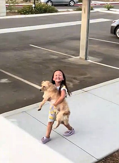 Anaiya, toda feliz, carregando o cachorrinho no colo.