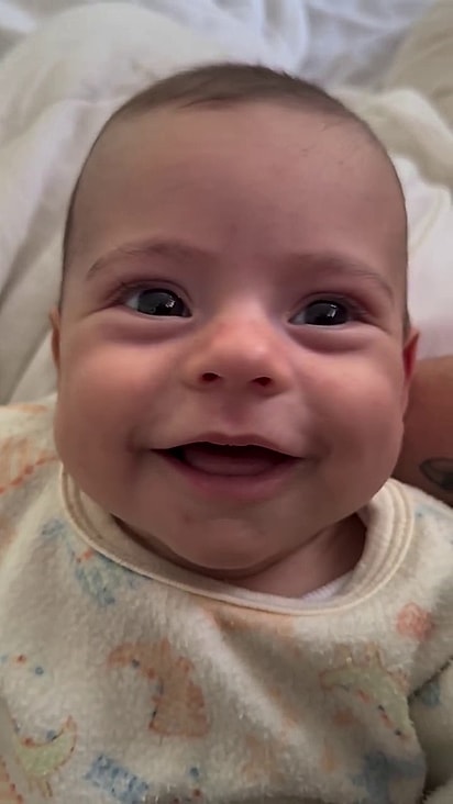 A bebezinha sorri toda vez que escuta o cão.