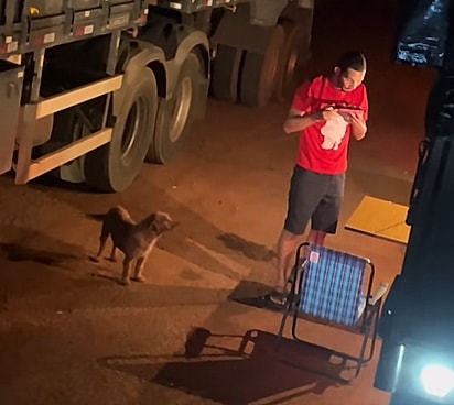 O homem assobrando a comida para o cão não se queimar.