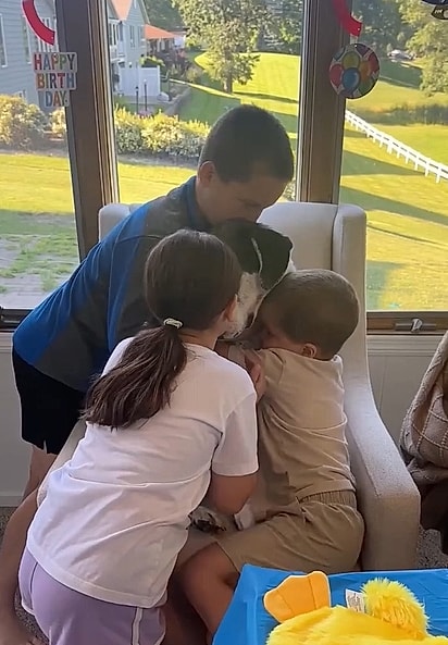 O cachorrinho Bruno abraçado por sua família.