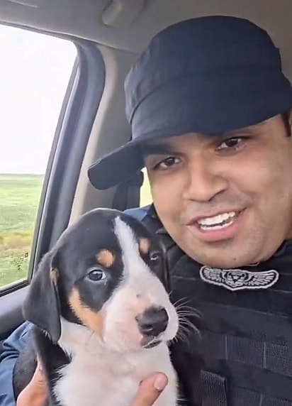 O Major segurando no colo o cachorrinho que resgatou.