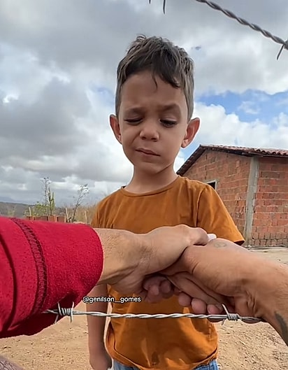 Genylson consolando o menininho.