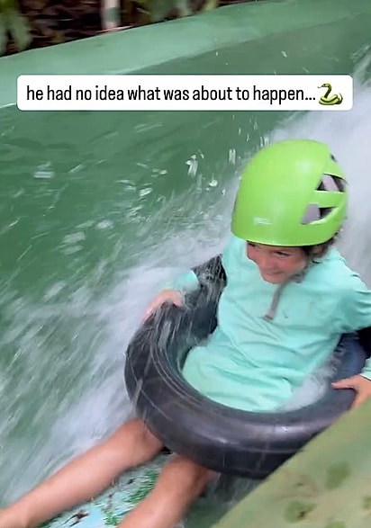 O garotinho se preparando para descer no toboágua.