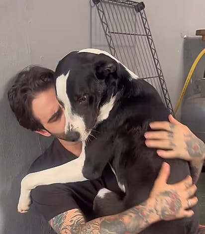 Nicolau aninhado no colo de Gustavo.