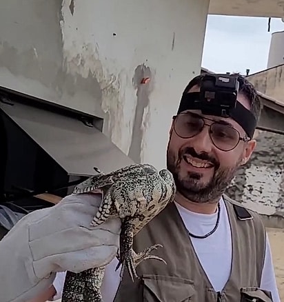 O lagarto mordendo amão do biólogo Gilberto Ademar Duwe.