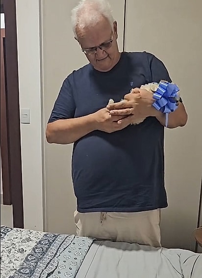O sogro ficou muito feliz com o novo cachorrinho.