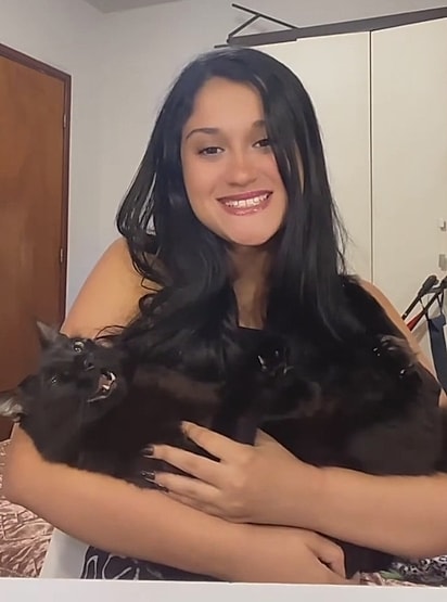 Milena com o gato Caquinho no colo.