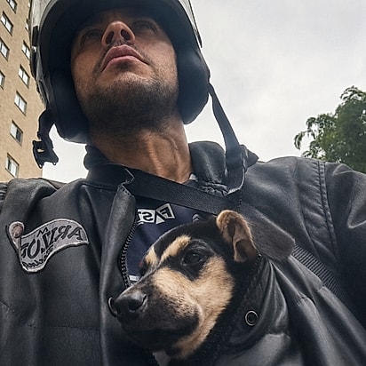 Preocupado, ele colocou o cão dentro da jaqueta e o levou para fazer entregas.