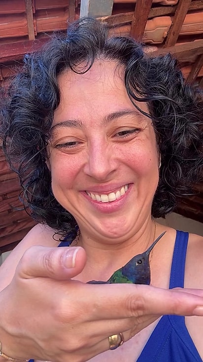 O beija-flor descansou na mão da mulher.